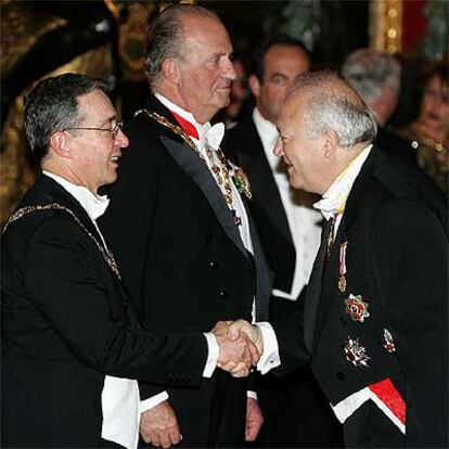 Álvaro Uribe saluda al ministro Moratinos en presencia del Rey en el Palacio Real.