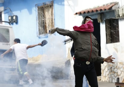 Um manifestante lança um objeto contra as forças de segurança.