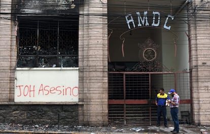 Un graffiti que dice "asesino de JOH", en referencia al presidente hondureño Juan Orlando Hernández, es visto como los funcionarios públicos consideran los daños causados al Ayuntamiento del distrito central durante los enfrentamientos luego de una protesta de estudiantes de la Universidad Nacional Autónoma de Honduras (UNAH) contra el aprobación de los proyectos de ley de educación y salud en el Congreso hondureño en Tegucigalpa. La policía hondureña dispersó con gas tetona a miles de personas que protestaron y bloquearon caminos en contra de la educación y las reformas de salud aprobadas por el Congreso.