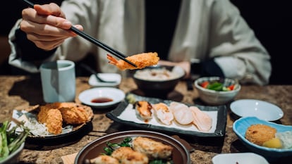 Una persona usando palillos para comer.