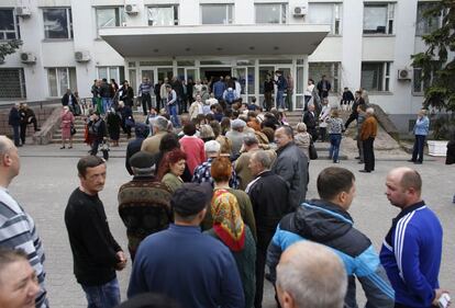 La gente se coloca en fila para entrar en un colegio electoral.