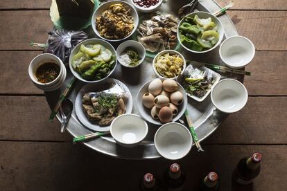 Comida con invitados en casa de Yayer y Ater: pollo relleno, verduras al vapor, salsa de chile, ensalada picante con carne, pollo cocido, huevos batidos a la parrilla… y cerveza BeerLao que solo beberán los hombres.