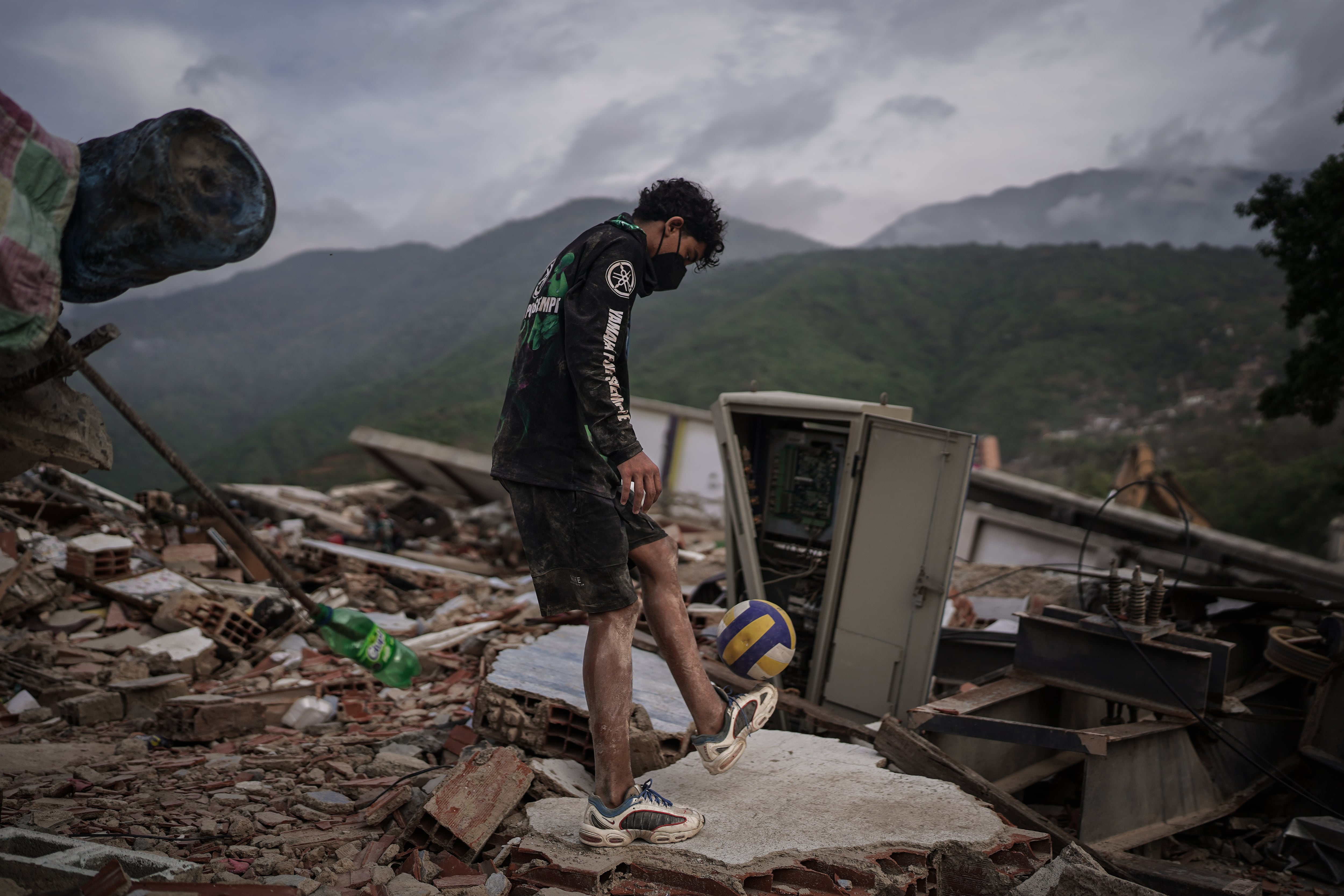 Un voluntario juega con una pelota sobre los escombros de un edificio, en La Guaira, el 3 de julio.