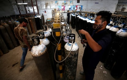 Operarios preparan botellas de oxígeno en Bangalore (India).