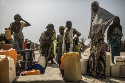 Un grupo de mujeres espera para recoger agua en el campo de Muna Garage, en Nigeria.