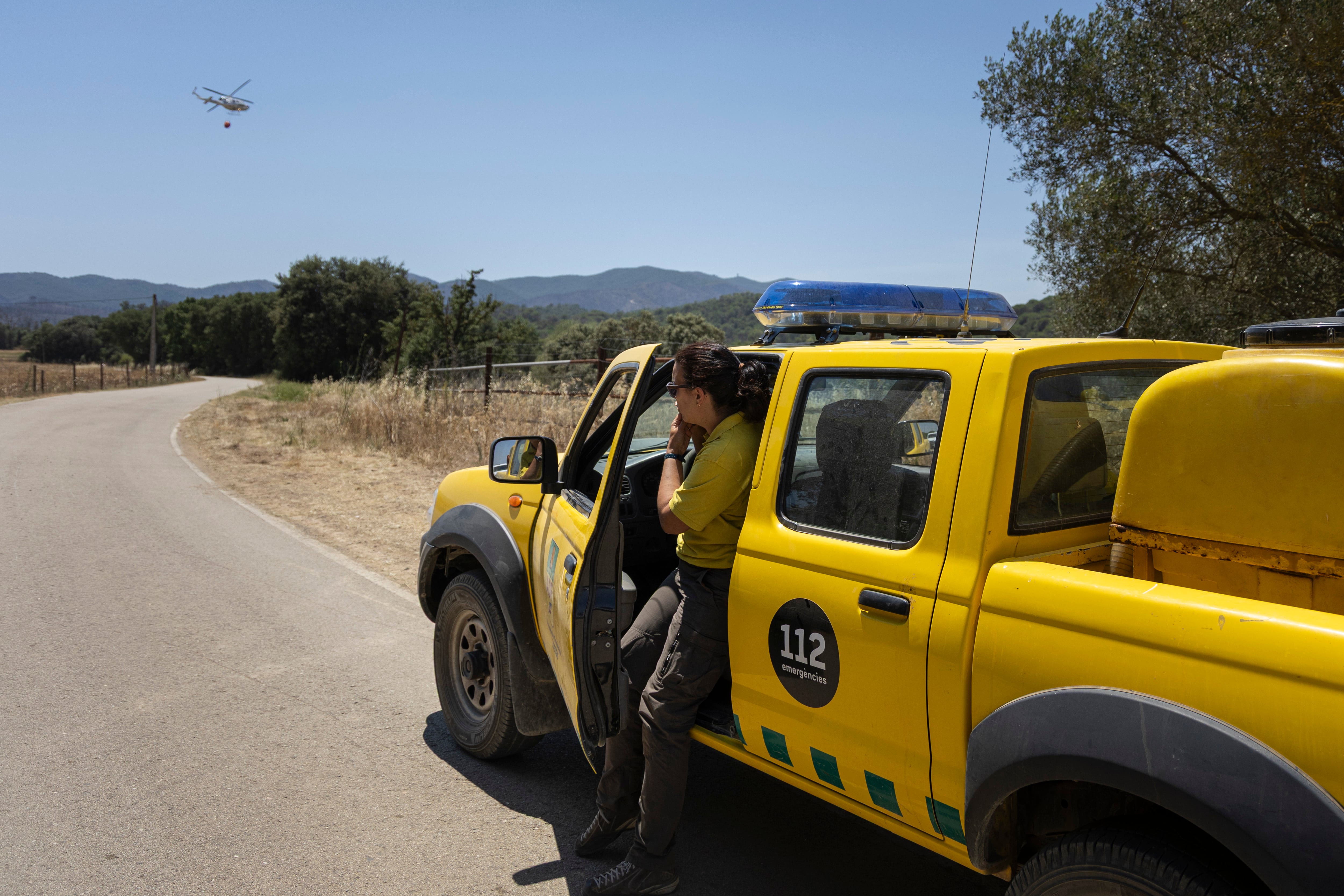 Sandra Torres, la coordinadora de la federación de Agrupaciones de Defensa Forestal (ADF) de Les Gavarres, el domingo, con su vehículo y un helicóptero de fondo.