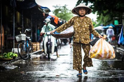 Una vendedora ambulante dirigiéndose al mercado de Hoi An. Todas las tardes en día de diario se pueden comprar pescados, frutas y múltiples especias de la gastronomía local.