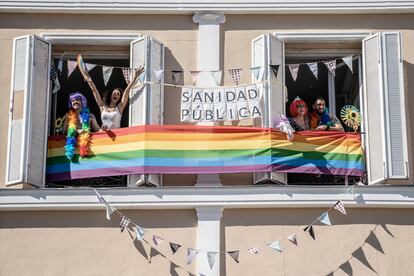 Vecinos de la plaza Pedro Zerolo celebran el día del Orgullo en su casa, mientras siguen la manifestación por Internet desde sus teléfonos moviles.
