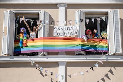 Vecinos de la plaza Pedro Zerolo celebran el día del Orgullo en su casa, mientras siguen la manifestación por Internet desde sus teléfonos moviles.