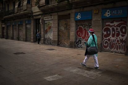 Una trabajadora sanitaria camina protegida contra el coronavirus por una calle de Barcelona.