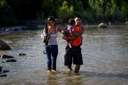 Una familia colombiana cruza el río Táchira.