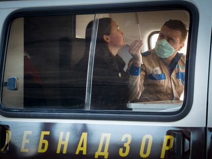 Um funcionário do Serviço Federal Russo de Vigilância coleta amostras para testar o coronavírus na estação de triagem especial ao ar livre no aeroporto de São Petersburgo, em 20 de março.