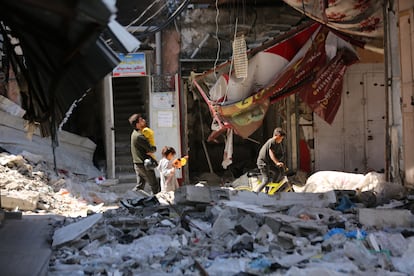 Ciudadanos palestinos atraviesan los restos de edificios devastados por los ataques israelíes en el norte de Gaza este martes.