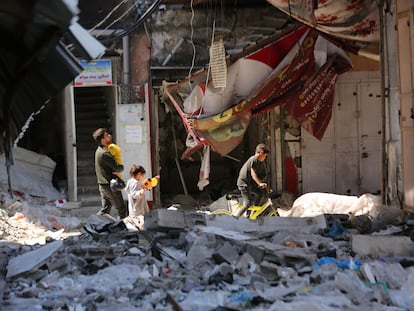 Ciudadanos palestinos atraviesan los restos de edificios devastados por los ataques israelíes en el norte de Gaza este martes.