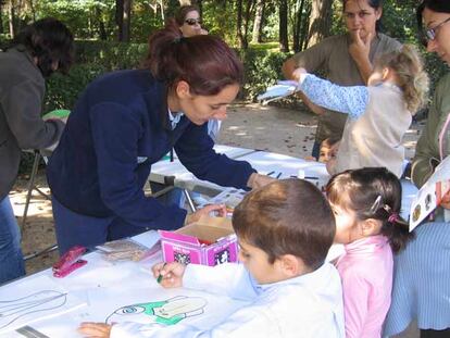 Varios niños dibujan en una actividad al aire libre en la Casa de Campo.