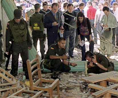 La policía colombiana examina los restos de la cafetería tras el atentado.