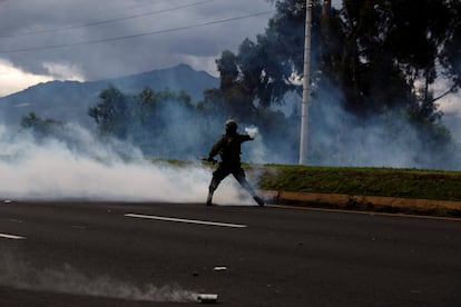 Un miembro de las fuerzas de seguridad ecuatorianas lanza un bote de gas lacrimógeno a los manifestantes indígenas que marchan hacia Quito, en Machachi, el 20 de junio de 2022.
