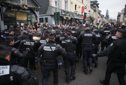 La policía antidisturbios francesa empuja a una multitud de manifestantes antes de la visita del presidente francés Emmanuel Macron a Grand Bourgtheroulde, Normandía.