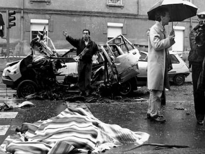 El cadáver del comandante Cortizo, cubierto por una manta, junto al coche destrozado por la bomba lapa.