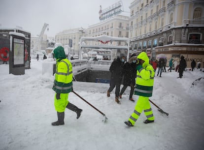 Unos operarios se disponen a limpiar la Puerta del Sol.