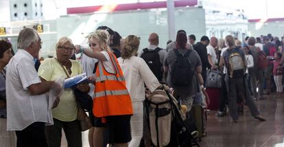 Una treballadora d'Aena informant viatgers a l'aeroport del Prat.