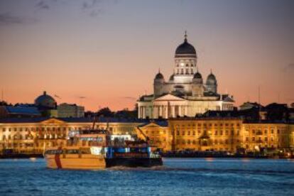 Un catamarán con la catedral de Helsinki al fondo.