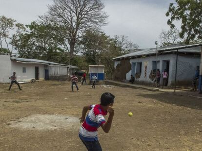 Un grupo de jóvenes juega al béisbol en el momento del almuerzo.