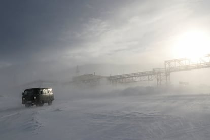 Un vehículo circula por una carretera cubierta de nieve cerca de las instalaciones de producción de la Compañía Minera y Metalúrgica de Kola (Kola MMC), una filial de la empresa de metales y minería Nornickel, en la ciudad de Monchegorsk en la región de Murmansk, Rusia. 