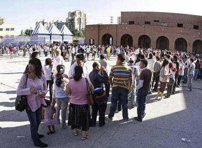 Una de las colas que se forman desde la entrada de la antigua cárcel de Carabanchel a la comisaría de la Vía de los Poblados.