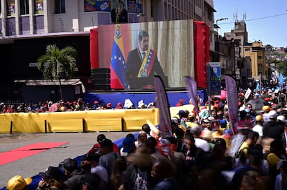 Varias personas observan una pantalla mientras Maduro jura su cargo para un tercer mandato de seis años.