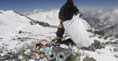 Un guía nepalés recoge, en 2010, basura dejada en el Everest.