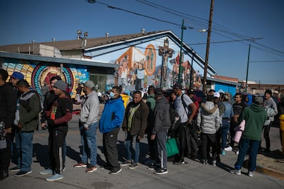 Migrantes se forman para recibir comida a un costado de un albergue, en El Paso, Texas. 