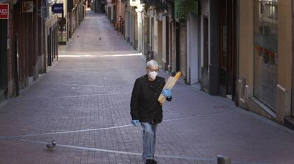 Una mujer pasa por una calle con todos los comercios cerrados en Terrassa.