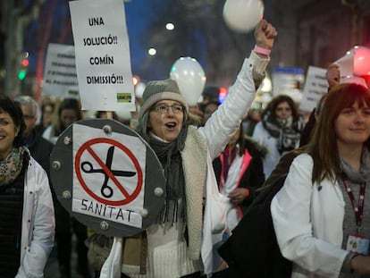 Una manifestante sostiene un cartel pidiendo la dimisi&oacute;n del consejero de salud, Toni Comin.