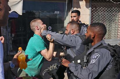 Un miembro de las fuerzas de seguridad israelíes empuja a un palestino en la Ciudad Vieja de Jerusalén, momentos antes de la Marcha de las Banderas, que celebra el aniversario de la ocupación israelí en 1967 del sector oriental de la ciudad.