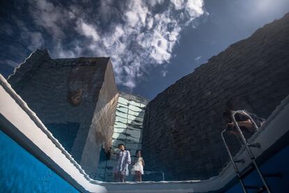 Visitantes observan la obra "Piscina" durante la exposición "Los confines del gran vacío" del artista argentino Leandro Erlich, en la Academia Central de Bellas Artes de China en Pekín.