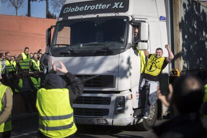 Un taxista se sube a uno de los camiones durante le corte de la Ronda Litoral de Barcelona.