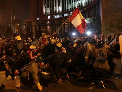 Un grupo de jóvenes sostienen la bandera peruana durante la marcha nacional del sábado 14 de noviembre contra la destitución de Martín Vizcarra en Lima