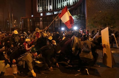 Un grupo de jóvenes sostienen la bandera peruana durante la marcha nacional del sábado 14 de noviembre contra la destitución de Martín Vizcarra en Lima