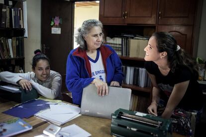 Camila Ruiz, de 18 años, se ríe junto a su maestra y una compañera tras terminar su clase de matemáticas en el instituto Santa Lucia. Cuando empezó a perder la visión comenzó a asistir a este centro para "reaprender" todo. Y hoy cursa todos sus estudios en braile.