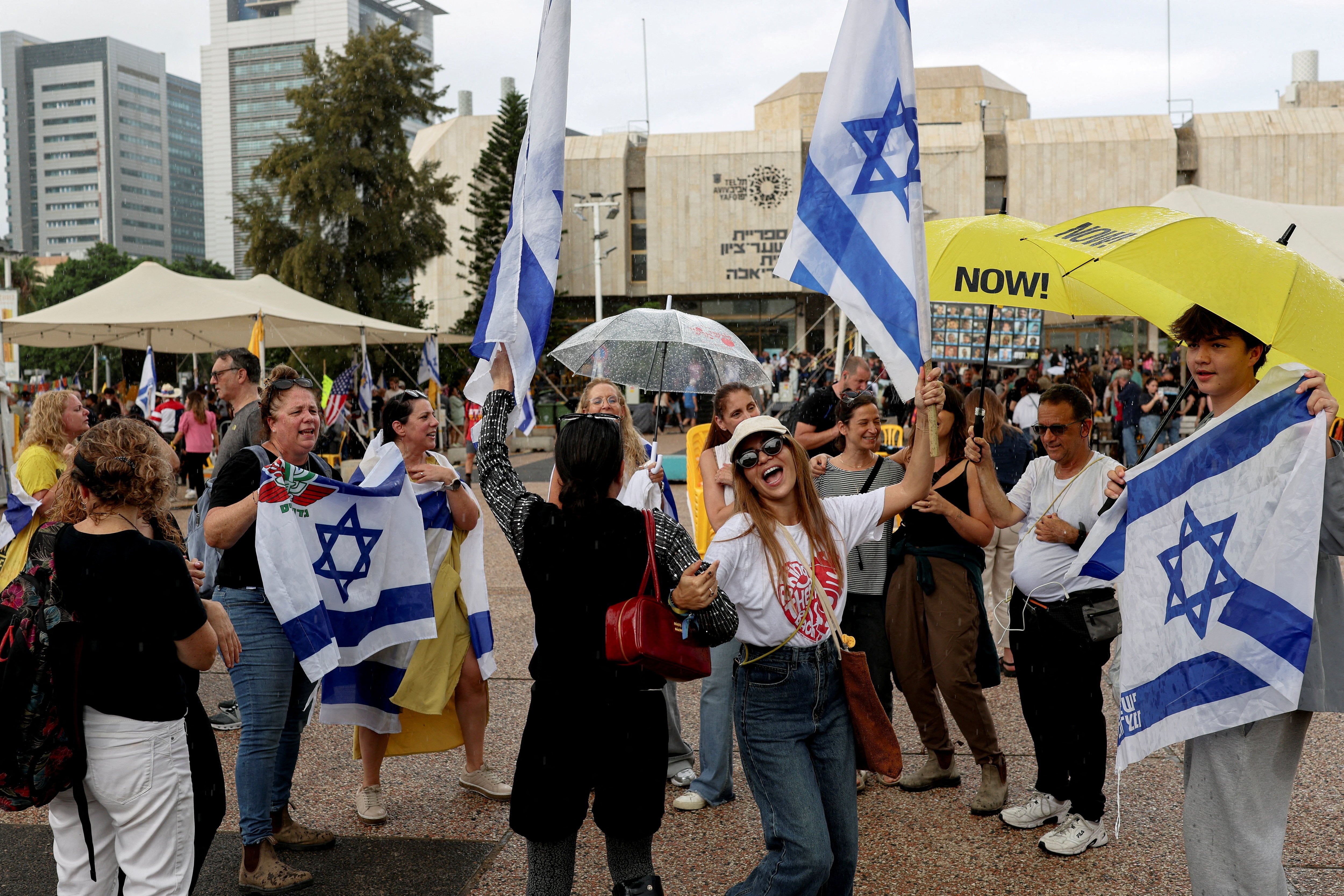 Gente con banderas de Israel celebrando el acuerdo de alto el fuego en Palestina, en la plaza de los Rehenes de Tel Aviv, el 9 de octubre.
