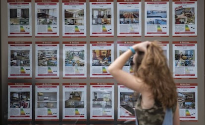 Una mujer pasa delante de una inmobiliaria en el barrio de Gràcia de Barcelona.