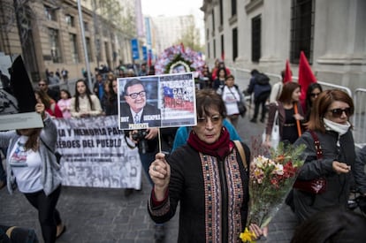 Mulher segura retrato do ex-presidente Allende, enquanto participa de manifestação diante do palácio presidencial de La Moneda, em Santiago.