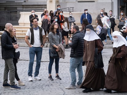Turistas sin mascarilla y dos monjas que sí la llevan, en el centro de Sevilla este lunes.