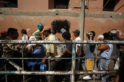 Prisioneros del penal García Moreno hacen fila para recoger agua