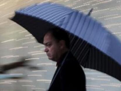 Un hombre se protegía ayer de la lluvia con un paraguas en el centro de Valencia