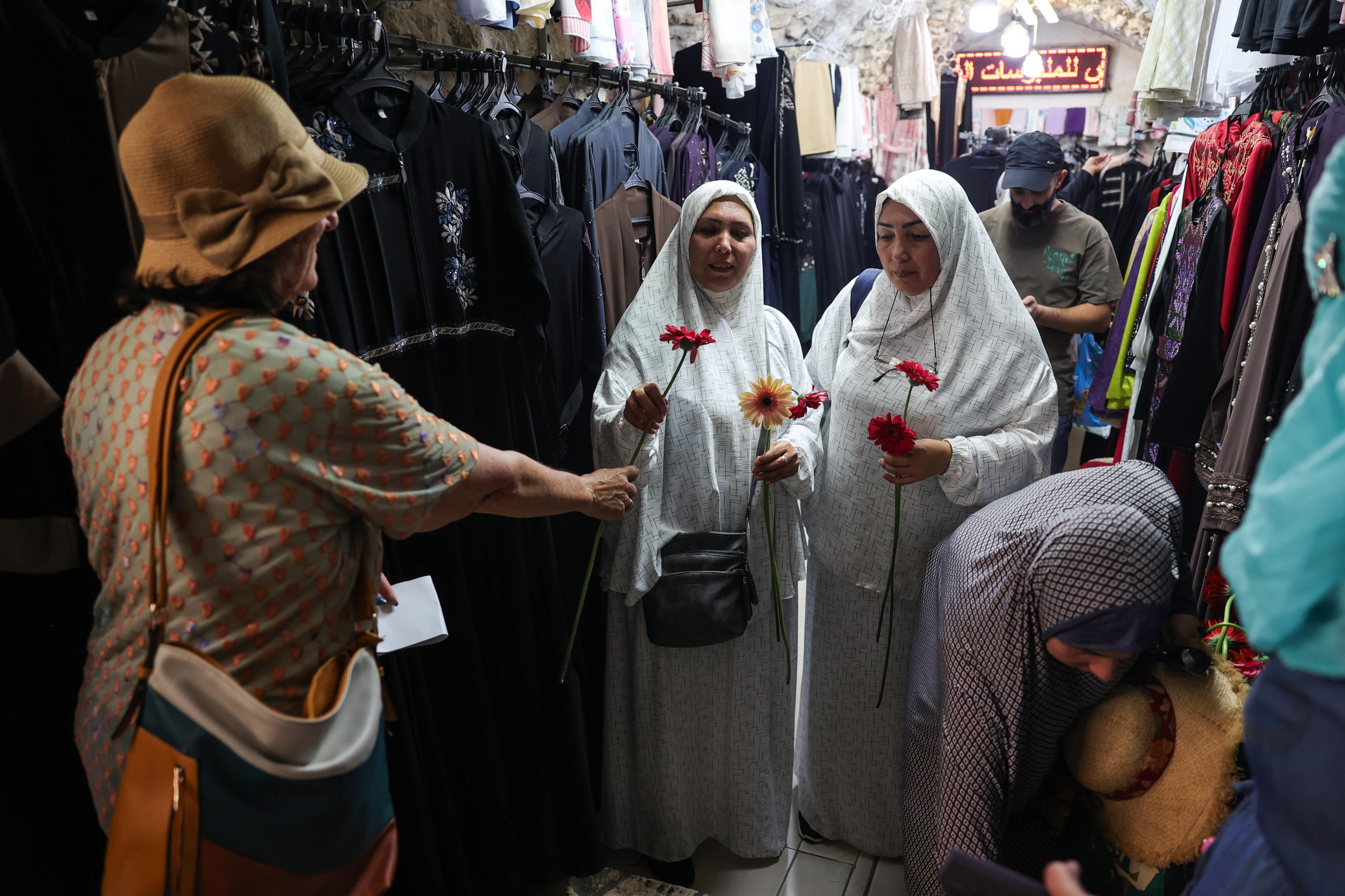 Residentes palestinos reciben flores de activistas por la paz israelíes durante el Desfile de las Flores.