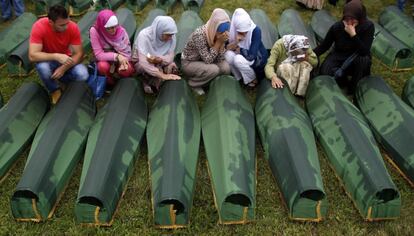 Bosnias lloran junto a varios féretros antes de su sepultura en el centro memorial de Potocari, 11 de julio de 2013. El crimen de Srebrenica fue cometido cuando las tropas serbobosnias conquistaron el enclave oriental bosnio, entonces protegido por cascos azules holandeses de la ONU.