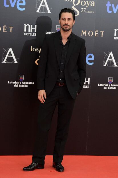 Hugo Silva se resiste a la pajarita o la corbata, pero no a la gomina. Su total look negro de pasaba por aquí no estaba a la altura de la gala (o de otros estilismos masculinos).