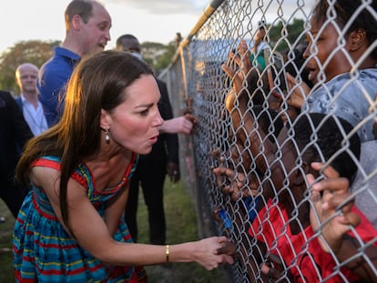 El príncipe Guillermo y su esposa Kate saludan a una multitud de niños negros agolpados en una alambrada en Kingston (Jamaica), en marzo.